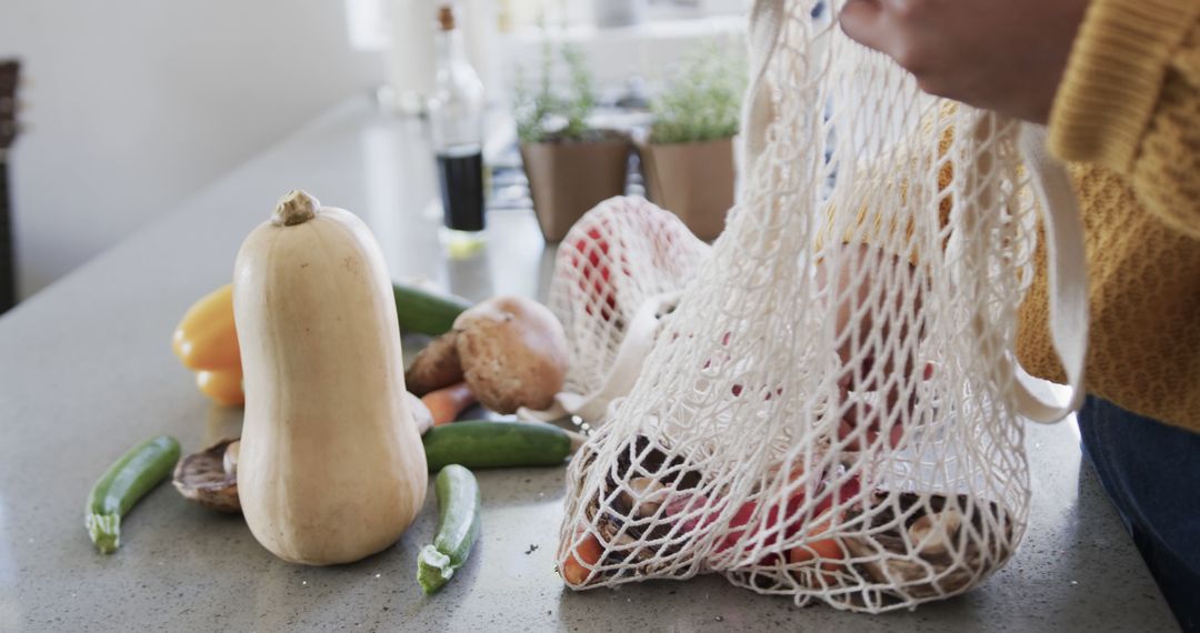 Person Using Reusable Mesh Grocery Bag with Fresh Vegetables - Free Images, Stock Photos and Pictures on Pikwizard.com