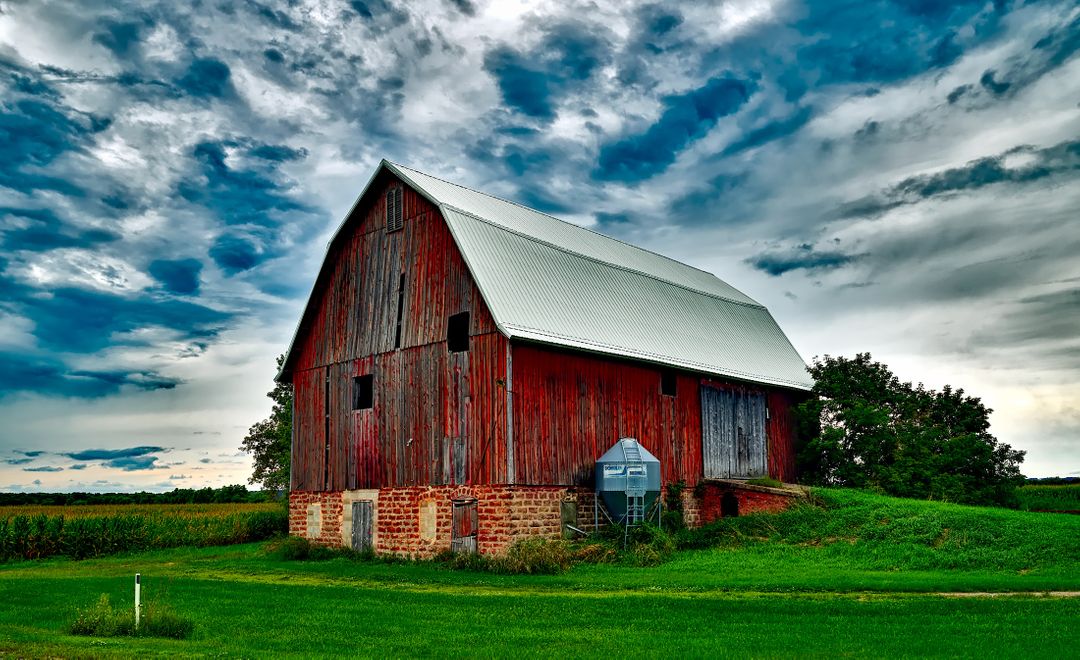 Old Wooden Barn on Green Grass Under Dramatic Cloudy Sky - Free Images, Stock Photos and Pictures on Pikwizard.com
