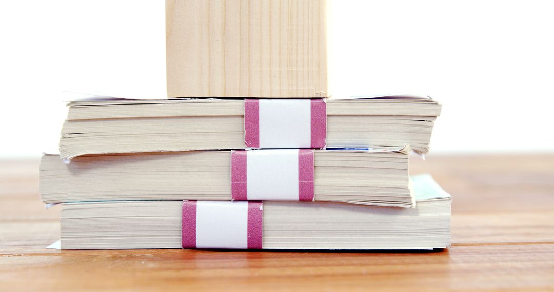 Close-Up of Stacked Paperback Books with Wooden Block - Free Images, Stock Photos and Pictures on Pikwizard.com