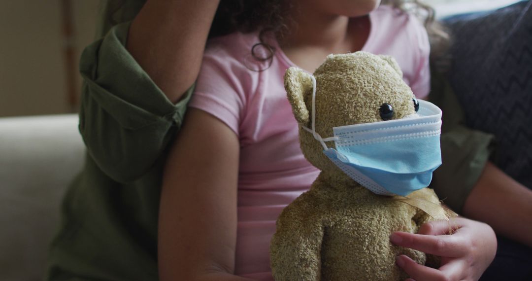 Child Holding Teddy Bear Wearing Medical Face Mask - Free Images, Stock Photos and Pictures on Pikwizard.com