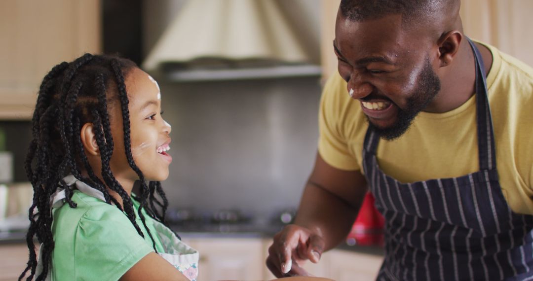 Smiling Father and Daughter Baking Together in Kitchen
