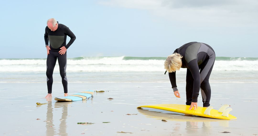 Senior Surfers Preparing Surfboards on Beach - Free Images, Stock Photos and Pictures on Pikwizard.com