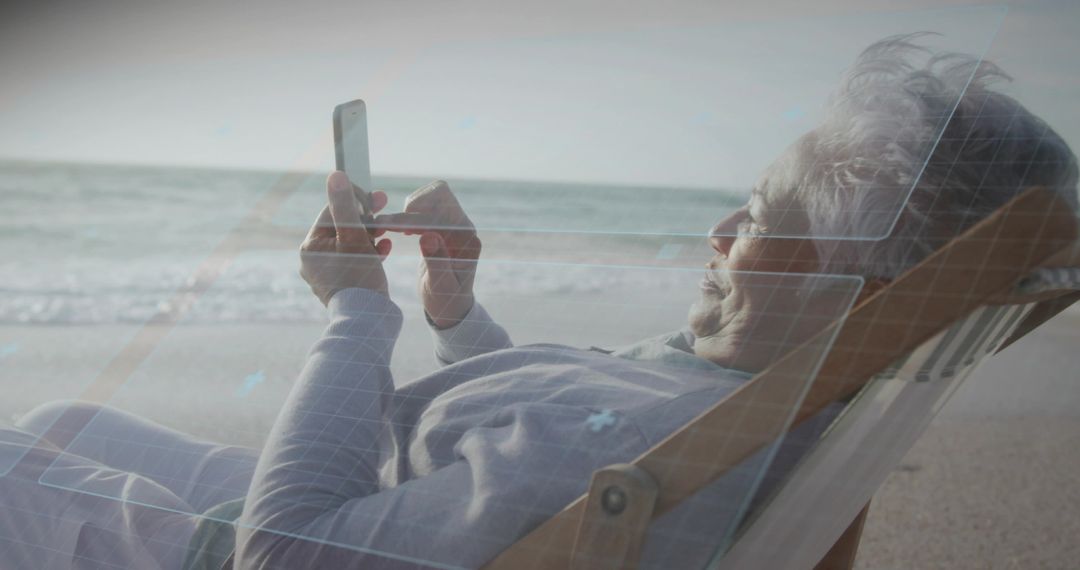 Senior woman reclining on beach using smartphone with digital overlay for remote lifestyle