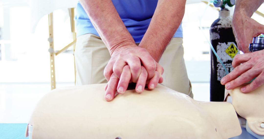 A person is practicing CPR on a training mannequin, with copy space - Free Images, Stock Photos and Pictures on Pikwizard.com