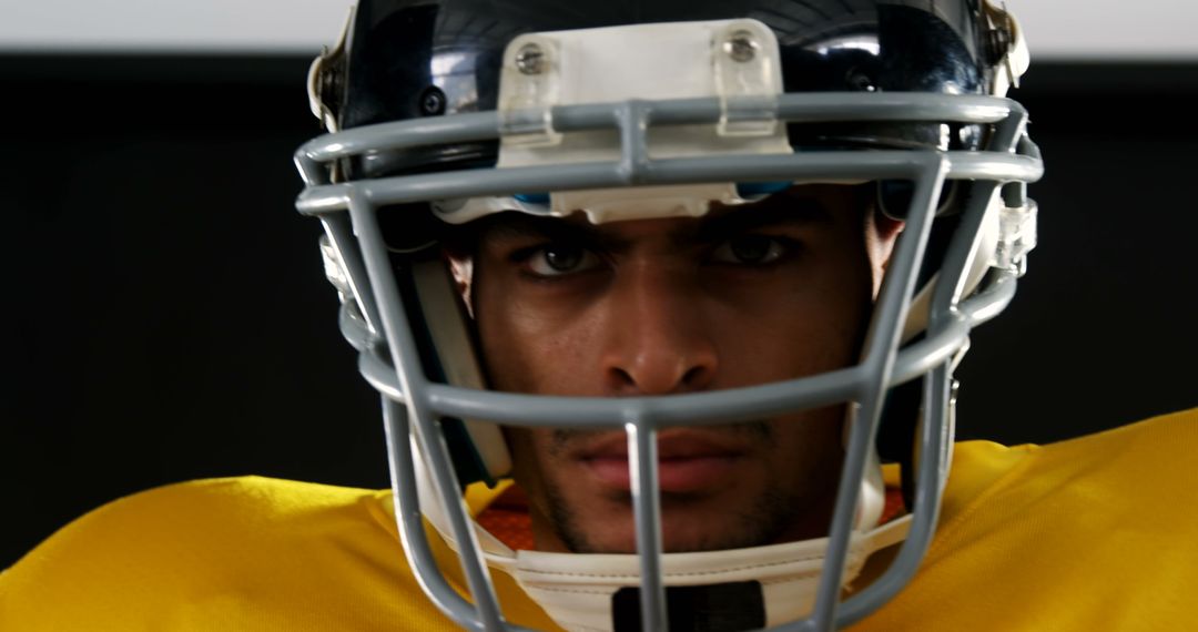 Determined Football Player in Helmet and Yellow Jersey - Free Images, Stock Photos and Pictures on Pikwizard.com