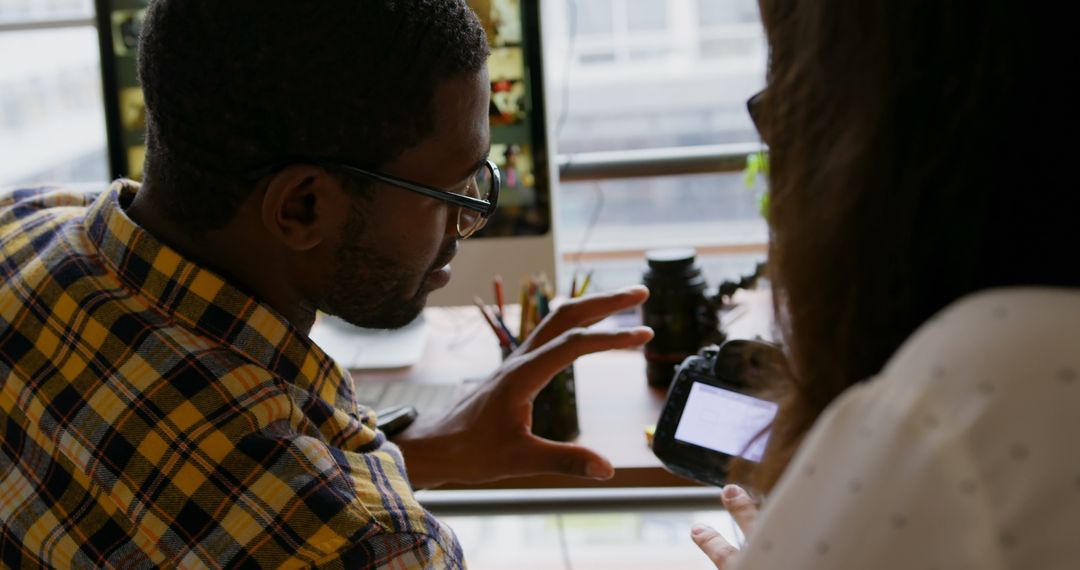 Graphic Designers Collaborating at Modern Office Desk