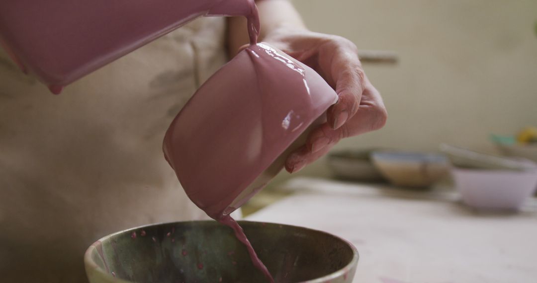 Close up view of female potter pouring paint from a jug on pot at pottery studio - Free Images, Stock Photos and Pictures on Pikwizard.com