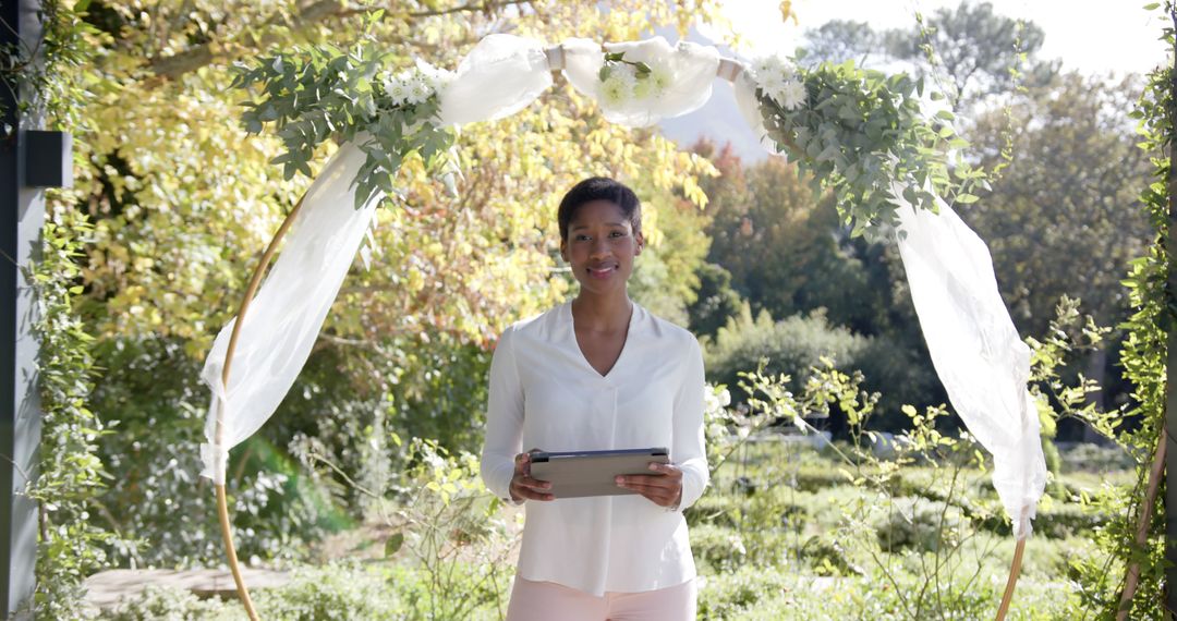 Smiling Woman Holding a Tablet During Outdoor Wedding Ceremony - Free Images, Stock Photos and Pictures on Pikwizard.com