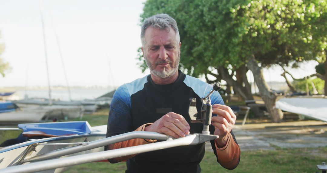 Senior Man Repairing Sailboat in Outdoor Marina - Free Images, Stock Photos and Pictures on Pikwizard.com