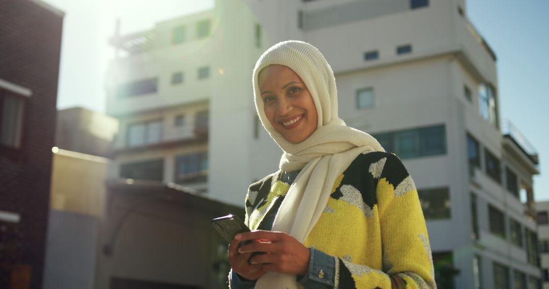 Smiling Woman with Hijab Using Smartphone Outdoors - Free Images, Stock Photos and Pictures on Pikwizard.com