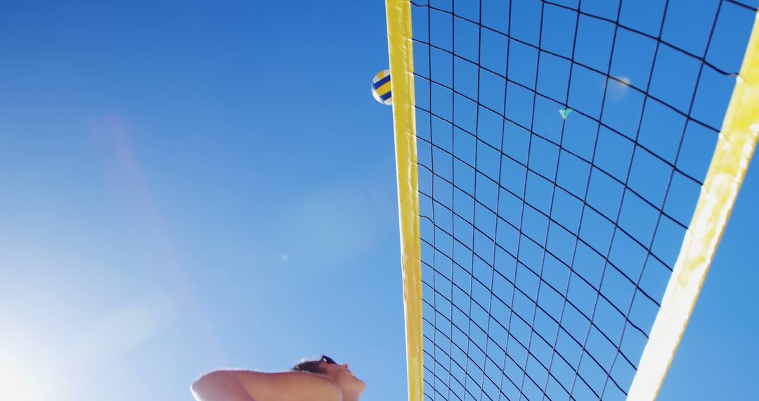 Woman Playing Beach Volleyball On Sunny Day Against Blue Sky - Free Images, Stock Photos and Pictures on Pikwizard.com