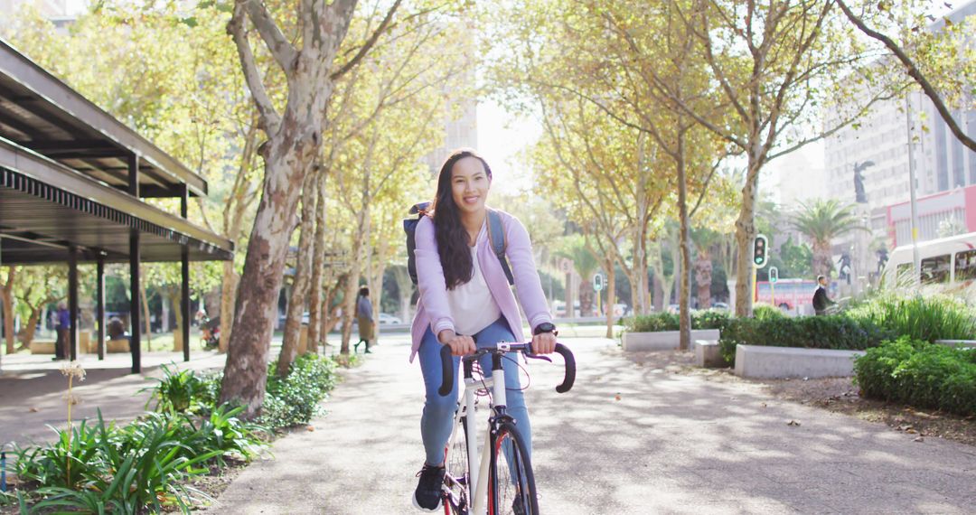 Smiling Woman Riding Bicycle in Park - Free Images, Stock Photos and Pictures on Pikwizard.com