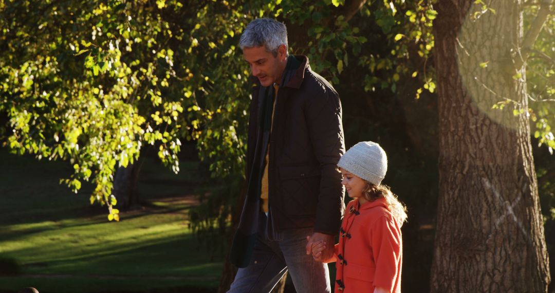 Father and Daughter Walking in Park During Autumn - Free Images, Stock Photos and Pictures on Pikwizard.com