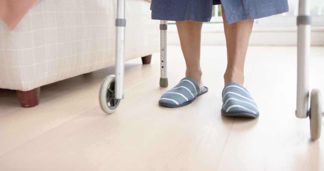 Elderly Person Using Walker Indoors with Striped Slippers - Free Images, Stock Photos and Pictures on Pikwizard.com