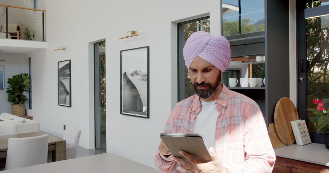 Man Wearing Turban Using Tablet in Modern Kitchen