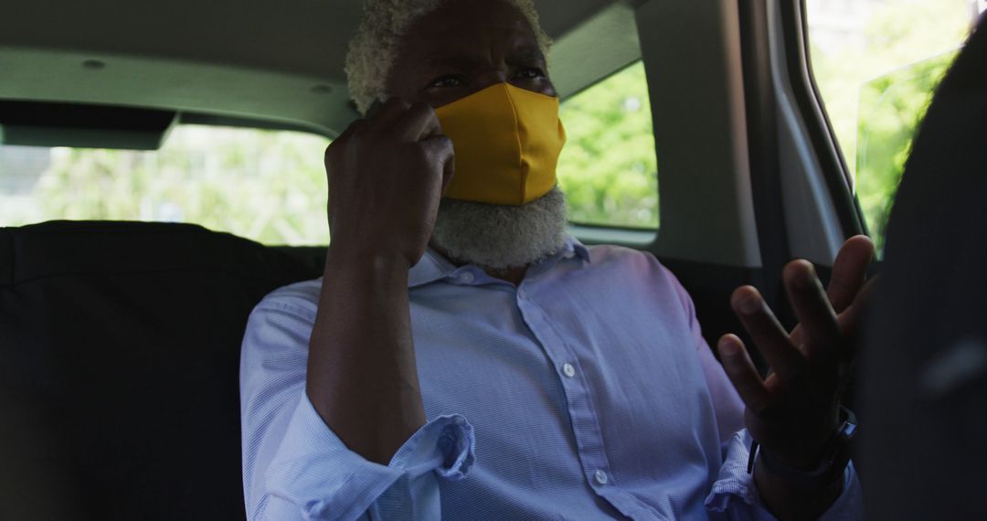 Mature Businessman in Car Adjusts Yellow Face Mask for Safety - Free Images, Stock Photos and Pictures on Pikwizard.com