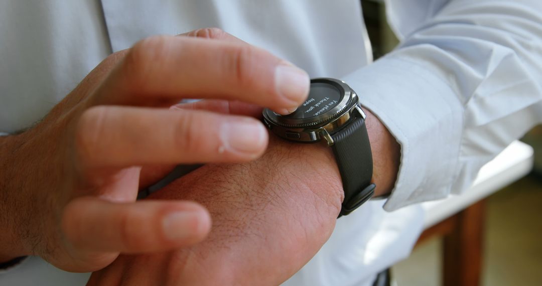 Businessman Checking Notifications on Smartwatch Wearing Formal Shirt - Free Images, Stock Photos and Pictures on Pikwizard.com