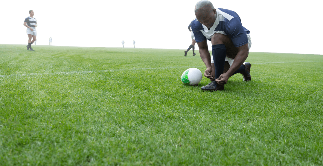 African American Rugby Player Tying Shoe on Transparent Background