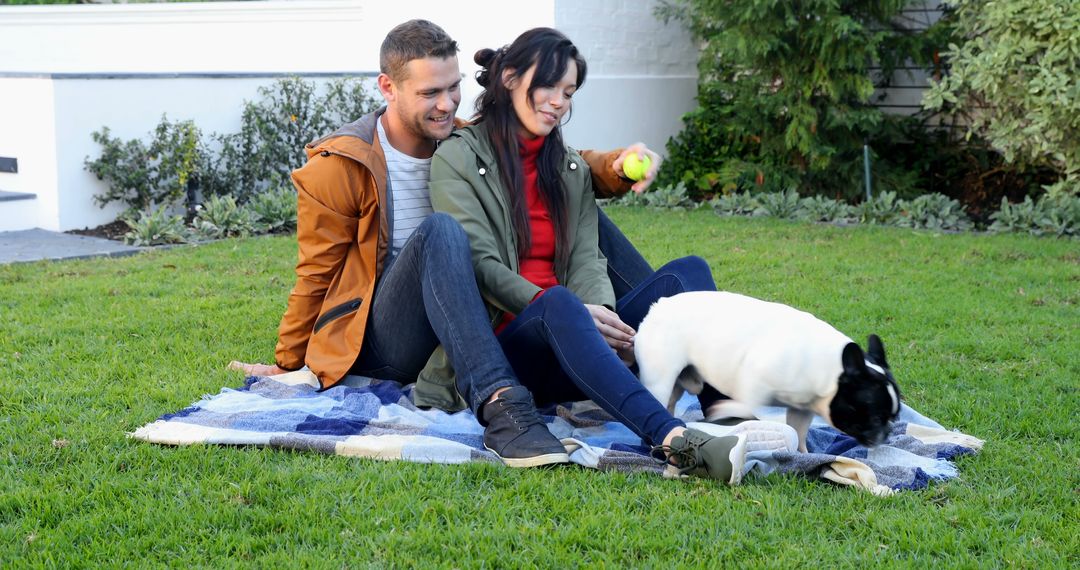 Couple Relaxing with Dog on Picnic Blanket in Garden - Free Images, Stock Photos and Pictures on Pikwizard.com