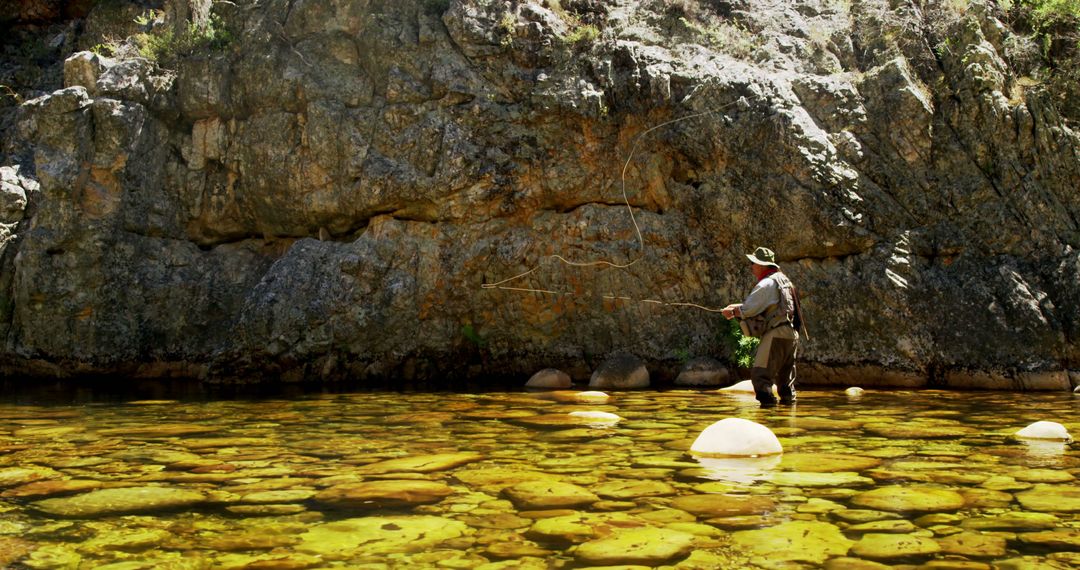 Man Fly Fishing in Rocky Stream amidst the Canyon - Free Images, Stock Photos and Pictures on Pikwizard.com