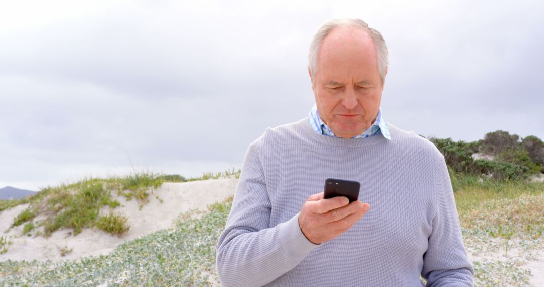 Senior man using smartphone on beach - Free Images, Stock Photos and Pictures on Pikwizard.com