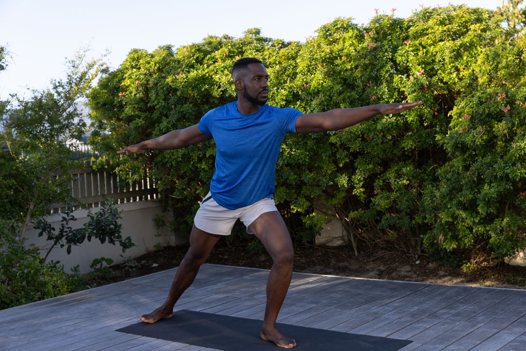 Mid Adult Man Practicing Warrior II Yoga Pose Outdoors