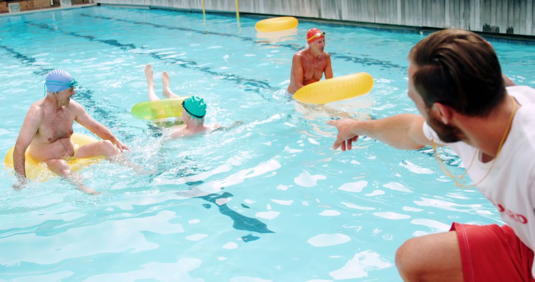 Swim Instructor Guiding Senior Swimmers On Relaxing Pool Day - Free Images, Stock Photos and Pictures on Pikwizard.com