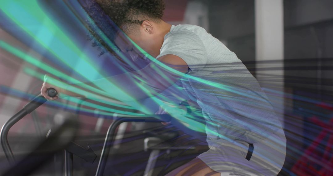 Man Exercising on Stationary Bike with Vibrant Light Streaks