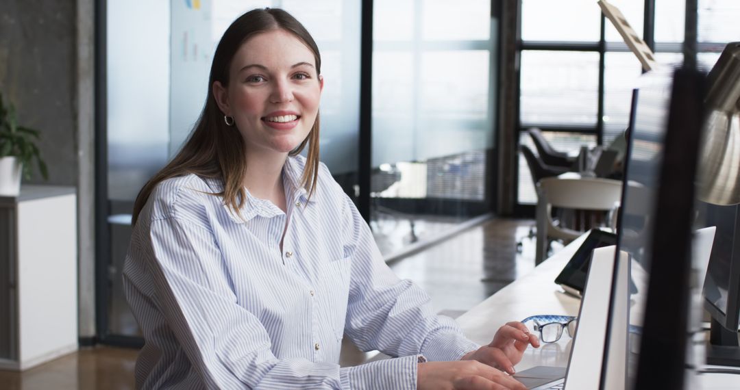 Smiling Professional Woman Working on Computer in Modern Office
