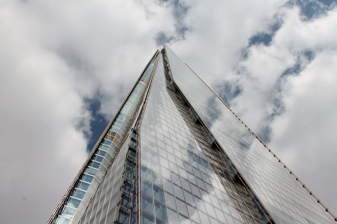 View of Modern Skyscraper with Reflective Glass and Cloudy Sky - Free Images, Stock Photos and Pictures on Pikwizard.com