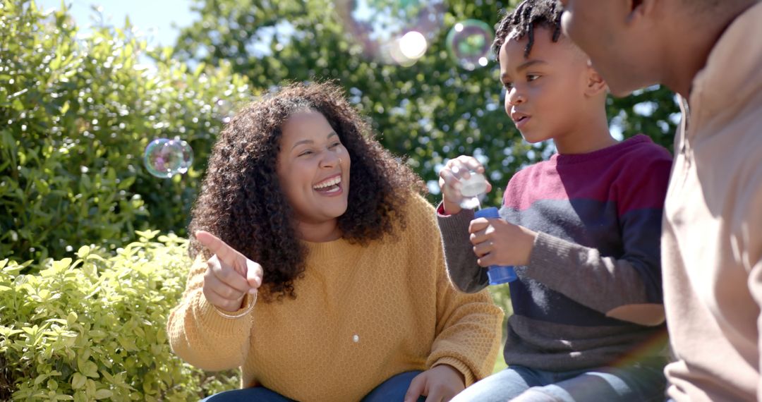 Happy African American Family Bonding Outdoors Blowing Bubbles - Free Images, Stock Photos and Pictures on Pikwizard.com