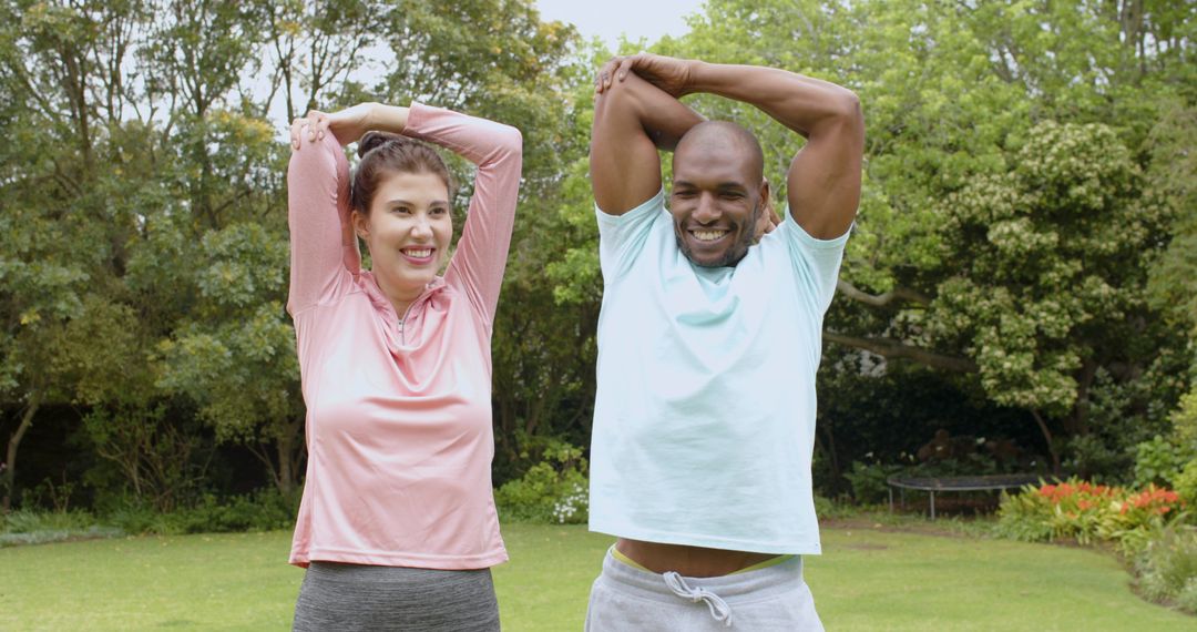 Smiling Couple Stretching Together in Tranquil Garden Setting