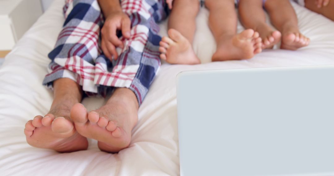Family Bonding Over Laptop in Cozy Bedroom Environment