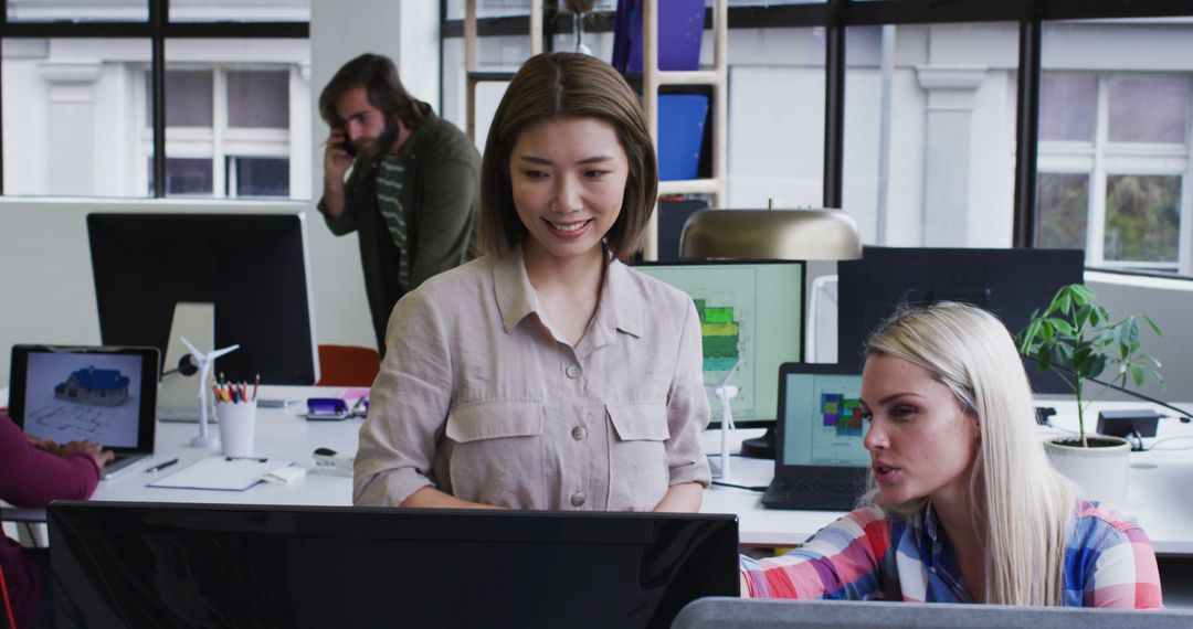 Diverse Office Team Collaborating on Project at Desk