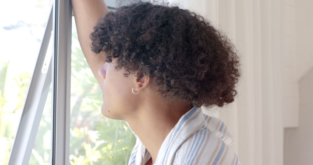 Man Relaxing at Window with Natural Light and Greenery