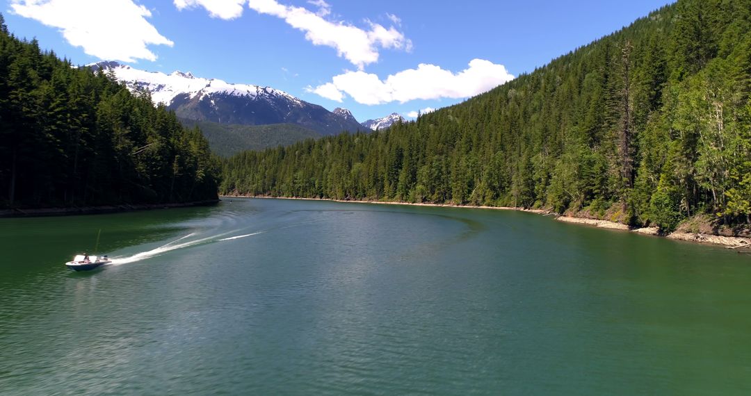 Speedboat on Serene Mountain Lake with Evergreen Forest - Free Images, Stock Photos and Pictures on Pikwizard.com