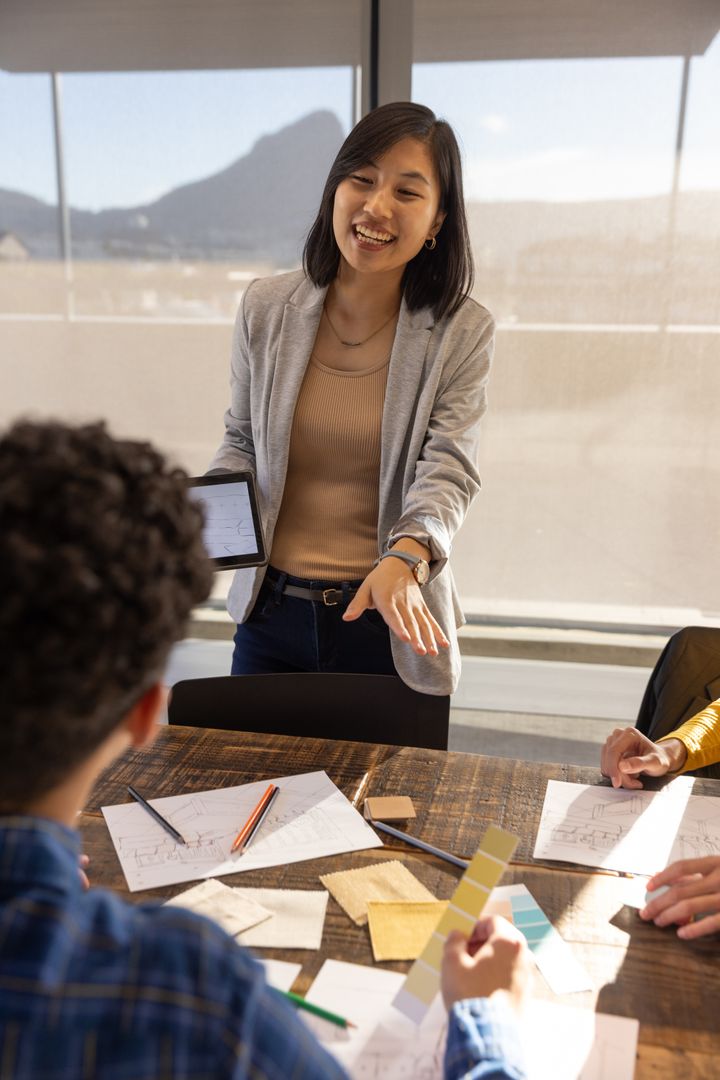 Team Collaborating on Design Projects Using Tablet in Modern Office