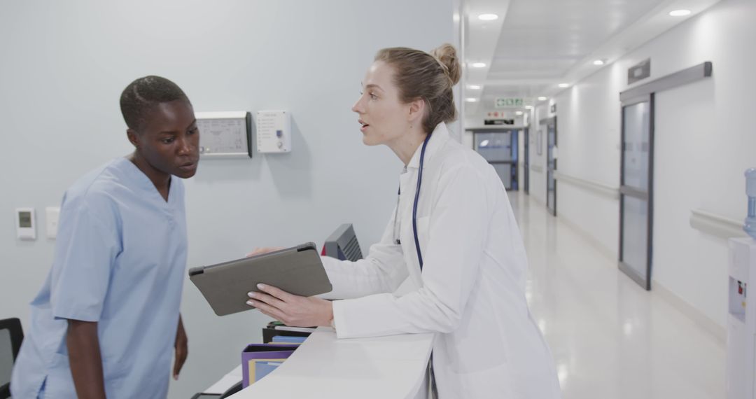 Medical Professionals Discussing Patient Care in Hospital Hallway - Free Images, Stock Photos and Pictures on Pikwizard.com