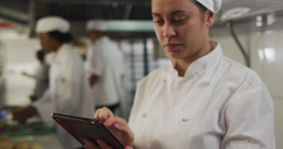 Professional Chef Using Digital Tablet in Restaurant Kitchen