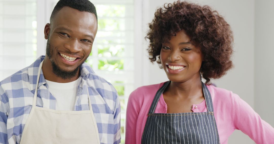 Smiling Couple Wearing Aprons in Bright Kitchen - Free Images, Stock Photos and Pictures on Pikwizard.com