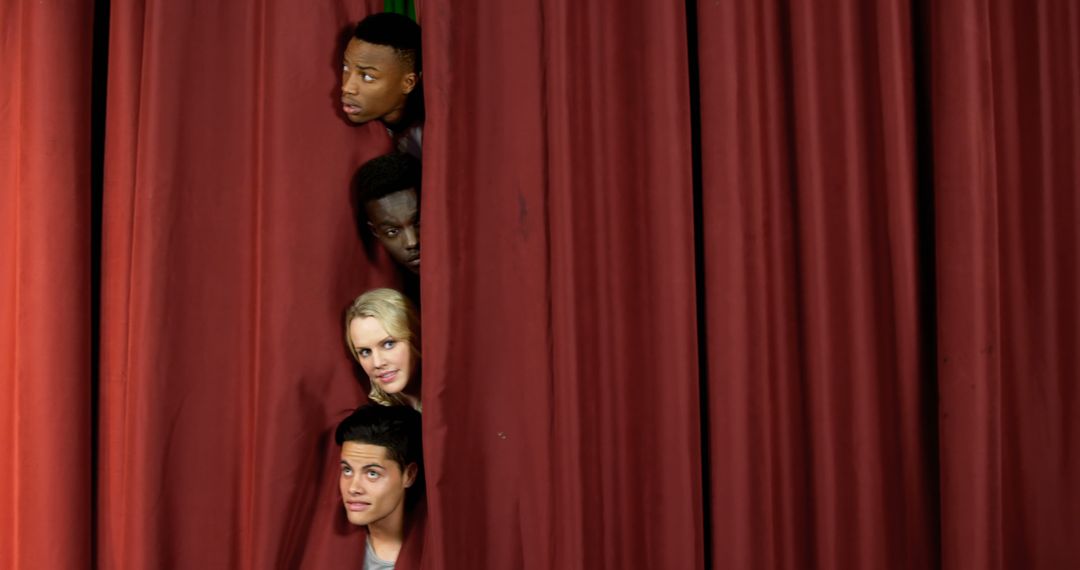 Four diverse actors are peeking through the curtains on a stage, with copy space - Free Images, Stock Photos and Pictures on Pikwizard.com