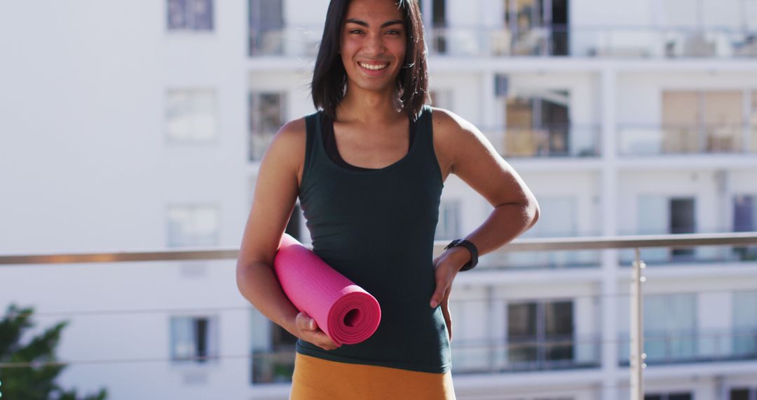 Smiling Woman Holding Yoga Mat on Balcony - Free Images, Stock Photos and Pictures on Pikwizard.com