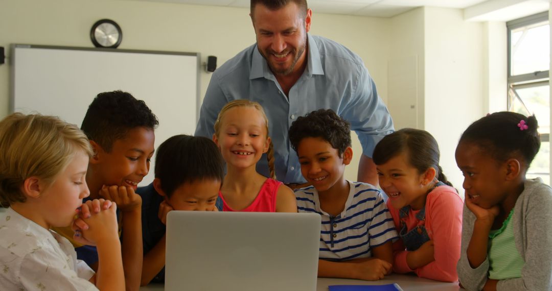 Happy Teacher Engaging with Diverse Students Using Laptop