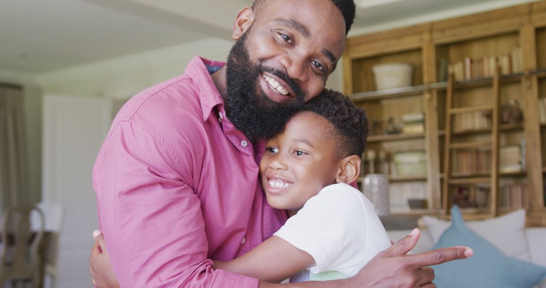 Smiling Father Hugging Son in Cozy Living Room - Free Images, Stock Photos and Pictures on Pikwizard.com