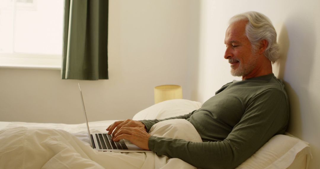 Senior man working on laptop from bed - Free Images, Stock Photos and Pictures on Pikwizard.com