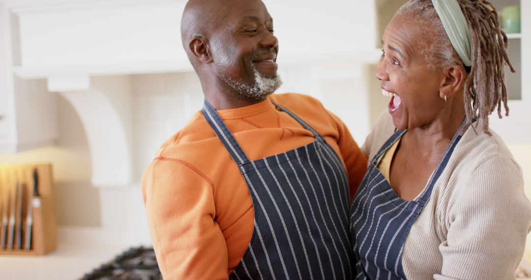 Senior Couple Embracing and Laughing in Kitchen