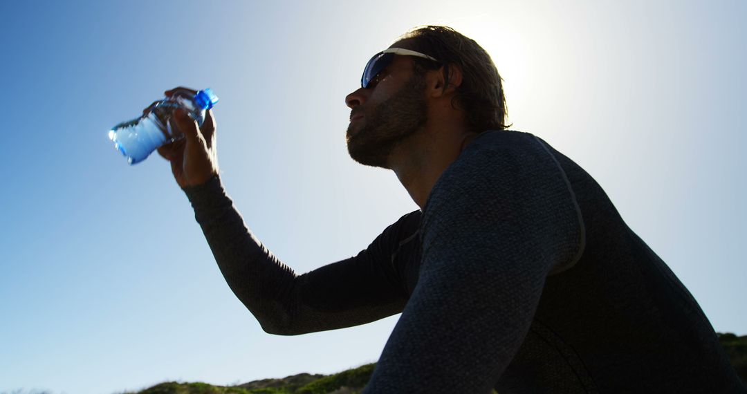 Athletic Man Drinking Water Outdoors on Sunny Day - Free Images, Stock Photos and Pictures on Pikwizard.com