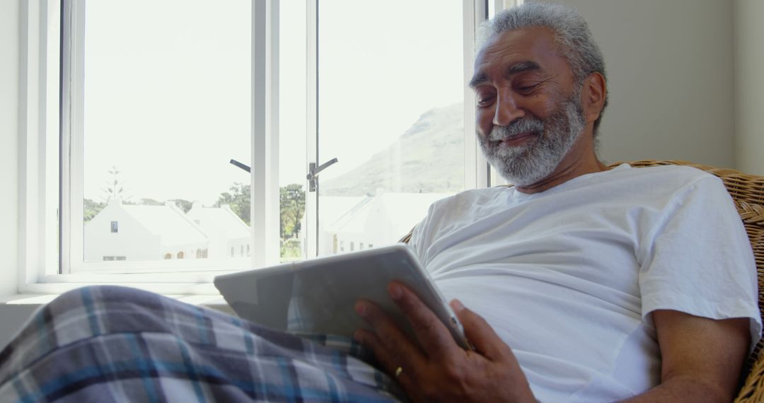 Senior Man Relaxing at Home Using Digital Tablet - Free Images, Stock Photos and Pictures on Pikwizard.com