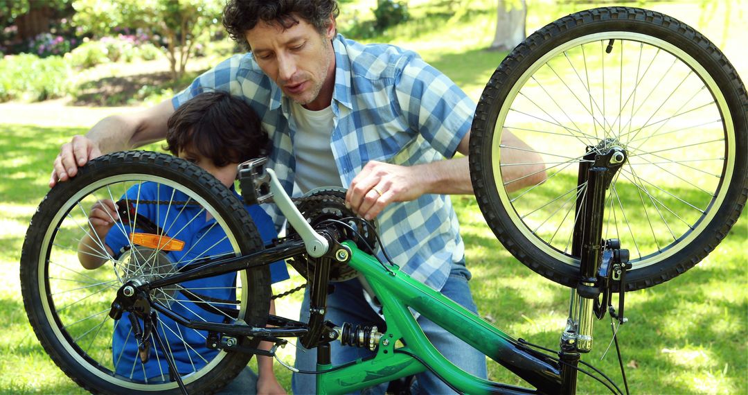 Father and Son Repairing Bicycle in Park - Free Images, Stock Photos and Pictures on Pikwizard.com