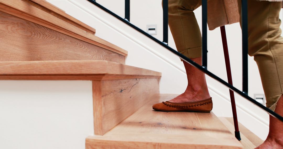 Close-Up of Senior Woman Climbing Wooden Stairs with Cane - Free Images, Stock Photos and Pictures on Pikwizard.com